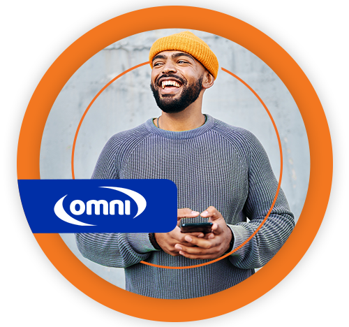 Homem negro, jovem, sorrindo, de gorro laranja e malha cinza, segurando um celular. 